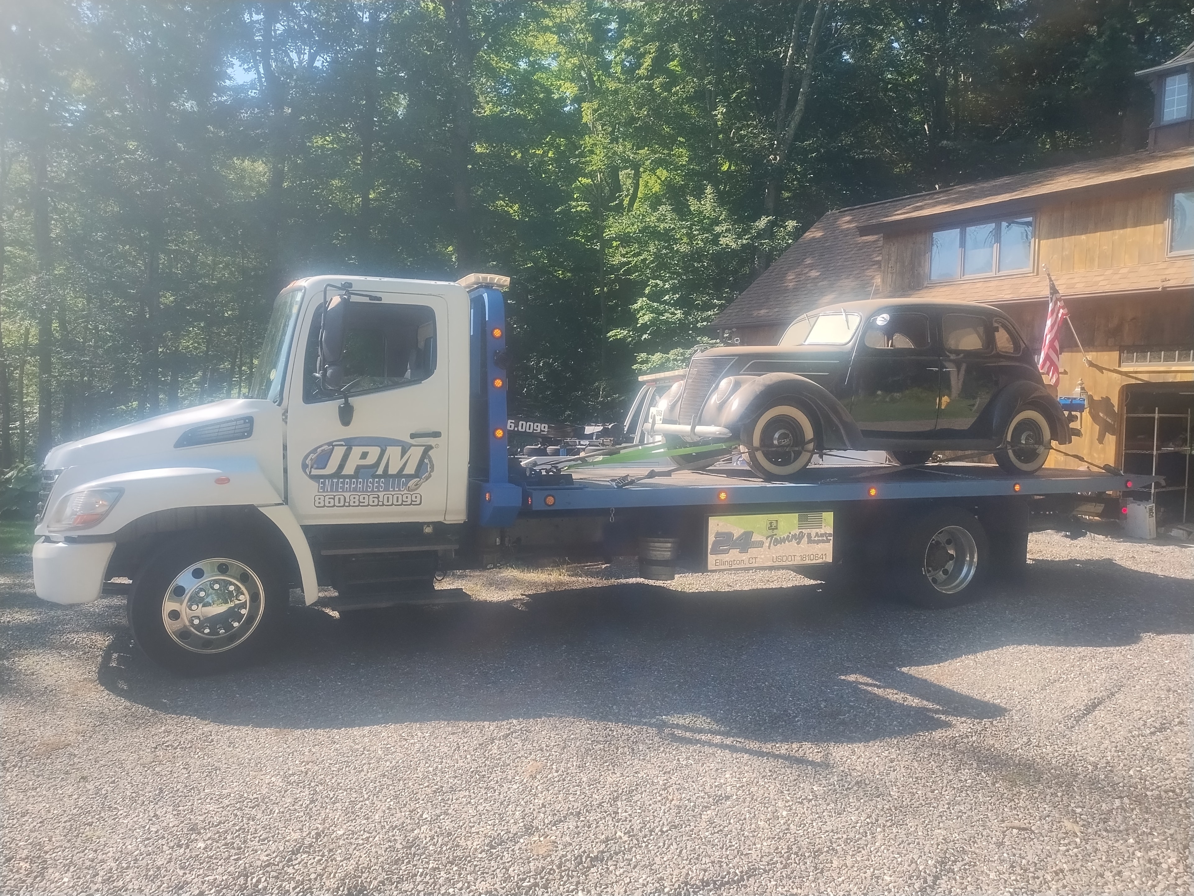 JPM Towing flatbed truck transporting a vintage car in Ellington, CT